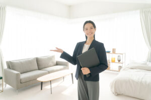家具のない部屋を案内する女性担当者