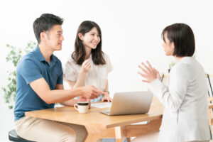 テーブルを囲んで話し合う3人