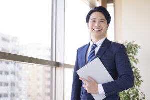 窓際で書類を持つ男性担当者