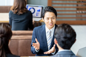打ち合わせで身ぶりを交えて説明する男性