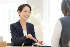 タブレットを示して話す女性担当者